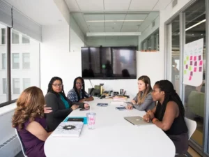 Picture of women sitting at a conference table during a meeting