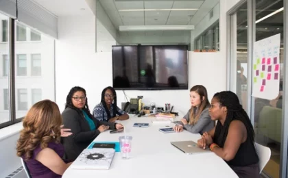 Picture of women sitting at a conference table during a meeting