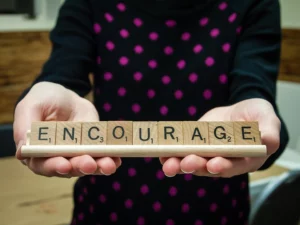 Women holding Scrabble word "Encourage"