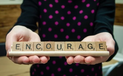 Women holding Scrabble word "Encourage"